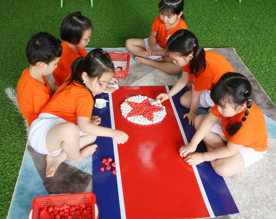 Các bé cùng vẽ, trang trí cờ hai nước Việt Nam-Triều Tiên. (Ảnh: Thanh Tùng/TTXVN)