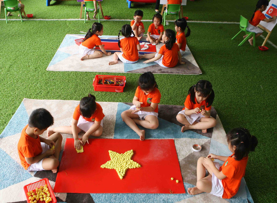 Các bé cùng vẽ, trang trí cờ hai nước Việt Nam-Triều Tiên. (Ảnh: Thanh Tùng/TTXVN)