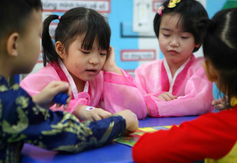 Các bé thích thú khi được mặc trang phục truyền thống của Triều Tiên. (Ảnh: Thanh Tùng/TTXVN)