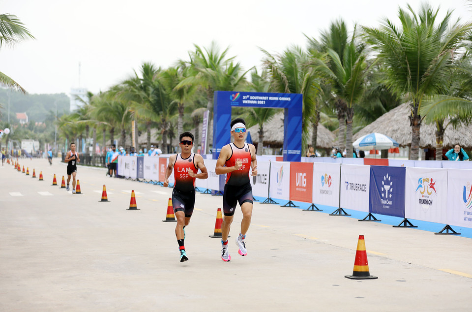 Hai vận động viên của Singapore chạy kèm nhau để giữ sức. (Ảnh: Công Đạt/TTXVN)