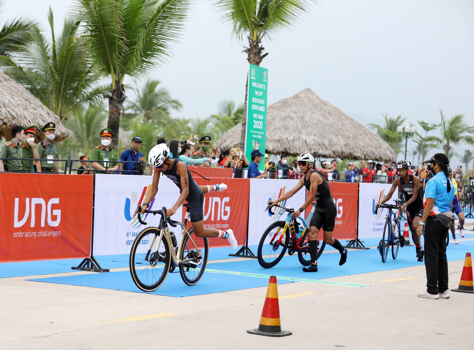 Các vận động viên kết thúc phần thi chạy đầu tiên để chuyển sang phần thi đạp xe với cự ly 40km. (Ảnh: Công Đạt/TTXVN)