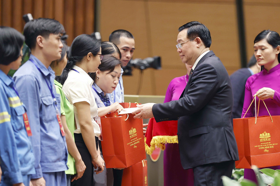 Chủ tịch Quốc hội Vương Đình Huệ tặng quà cho người lao động tiêu biểu. (Ảnh: Doãn Tấn/TTXVN)