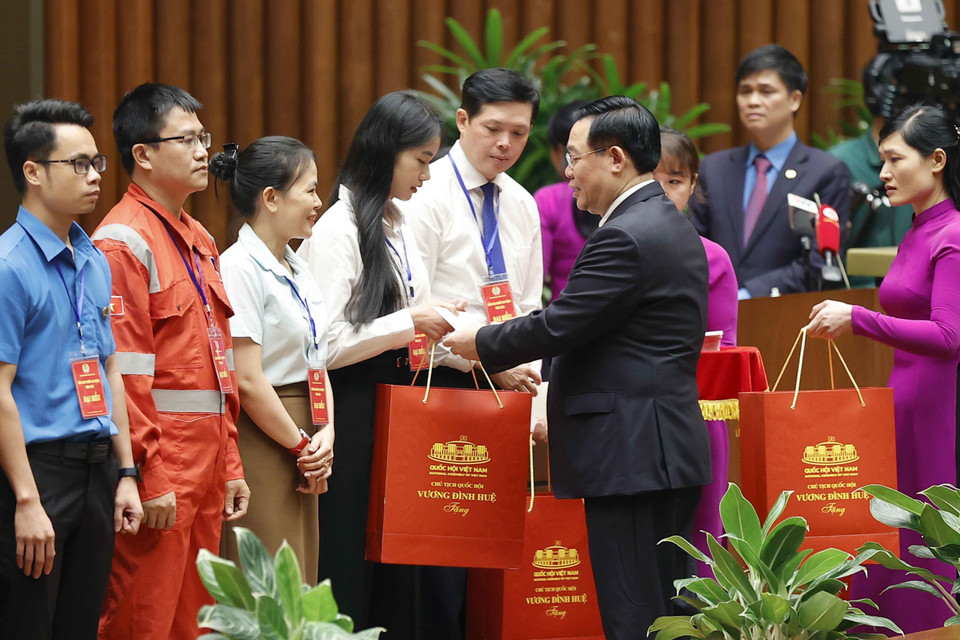 Chủ tịch Quốc hội Vương Đình Huệ tặng quà cho người lao động tiêu biểu. (Ảnh: Doãn Tấn/TTXVN)