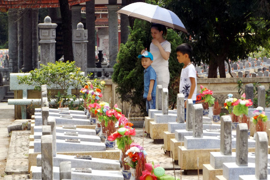 Các em nhỏ được gia đình dẫn tới nghĩa trang tưởng nhớ các liệt sỹ. (Ảnh: T.H/Vietnam+)