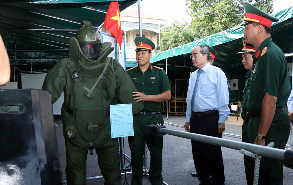 Ông Nguyễn Thiện Nhân, Ủy viên Bộ Chính trị, Bí thư Thành ủy Thành phố Hồ Chí Minh tham quan khu vực giới thiệu trang dụng cụ rà phá mìn. (Ảnh: Xuân Khu/TTXVN)