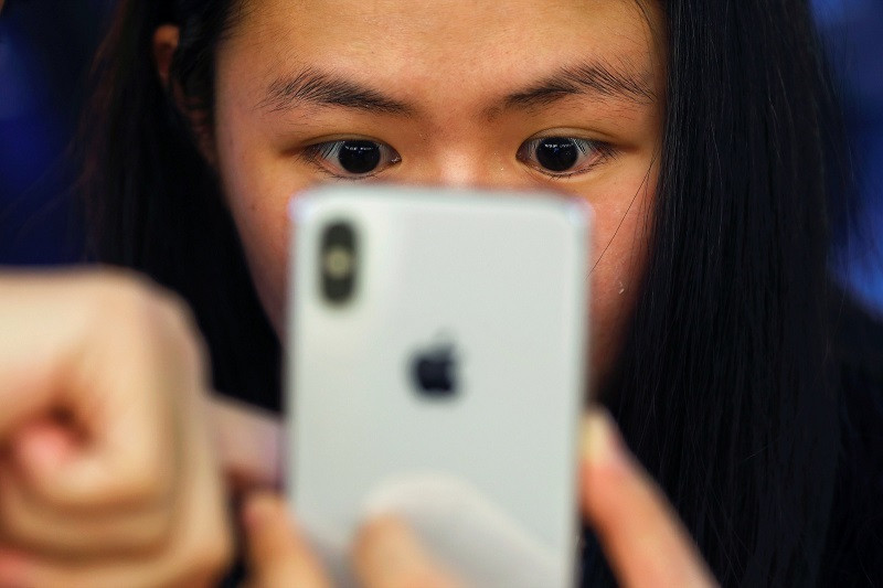 Một khách hàng đang thử iPhone X mới tại Bắc Kinh. (Nguồn: Reuters)