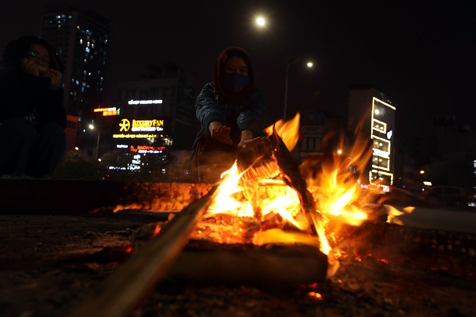 Người dân sưởi ấm bên đống lửa ven đường. (Ảnh: Phan Tuấn Anh/TTXVN)