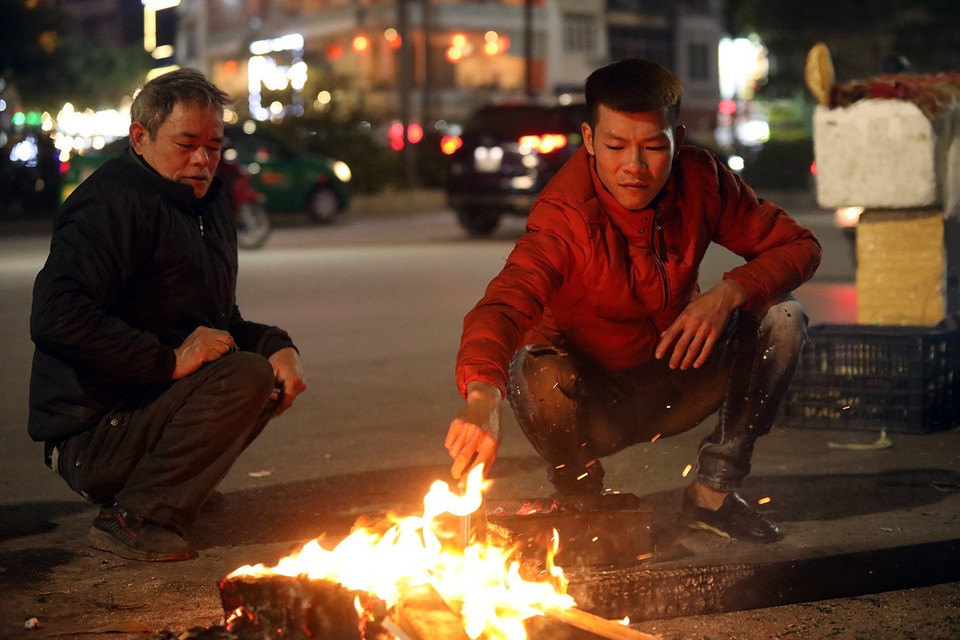 Người dân đốt lửa lấy than để nướng ngô bán cho người đi đường. (Ảnh: Phan Tuấn Anh/TTXVN)