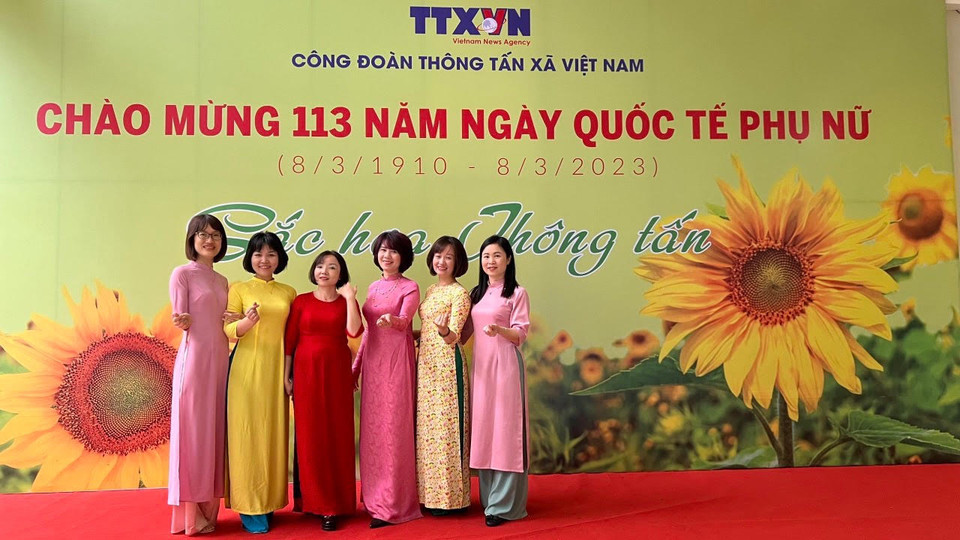 Các nữ cán bộ, viên chức lao động Nhà xuất bản Thông tấn hưởng ứng "Tuần lễ Áo dài". (Ảnh: TTXVN)