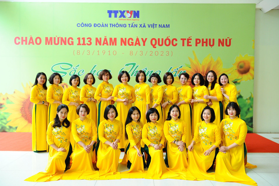 Nữ biên tập viên, họa sĩ của Trung tâm Thông tin tư liệu và Đồ họa thướt tha trong đồng phục áo dài. (Ảnh: Minh Đức/TTXVN)