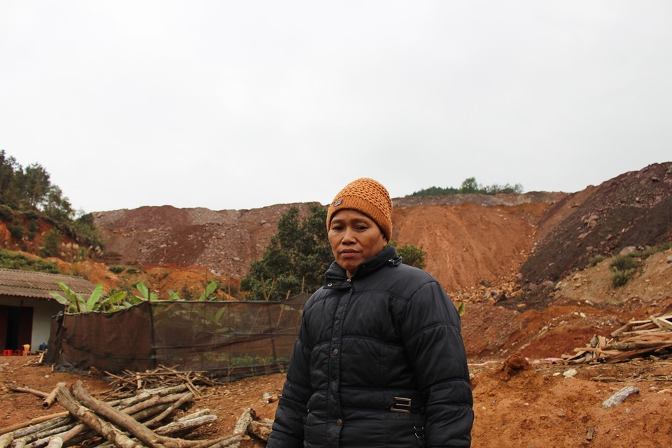 Bà Lâm Thị Vẫy, một người dân ở tổ 14, phường Tân Giang buồn rầu nhìn bãi đá thải khổng lồ vây quanh nhà. (Ảnh: Hùng Võ/Vietnam+)