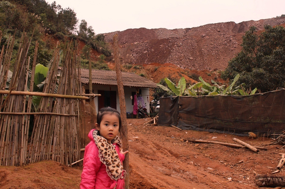 Những đứa trẻ hôn nhiên chơi đùa bên bãi đá thải khổng lồ ở tổ 14, phường Tân Giang. (Ảnh: Hùng Võ/Vietnam+)