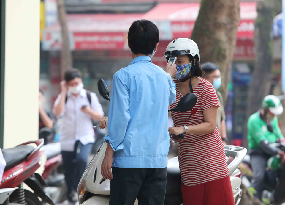 Tất cả giáo viên và học sinh đều được đo kiểm tra thân nhiệt trước khi vào trường theo đúng quy định. (Ảnh: Thành Đạt/TTXVN)