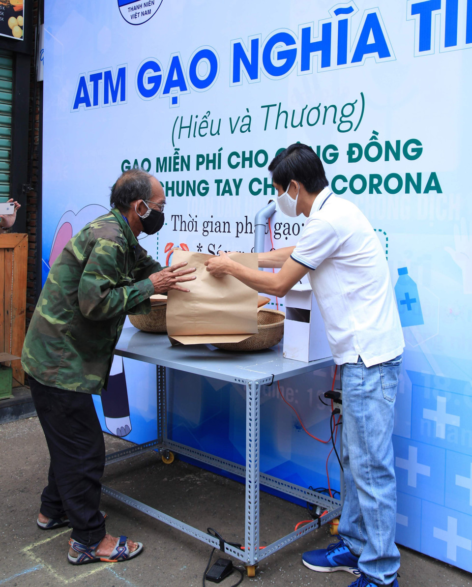 Người dân nghèo tại Đắk Lắk nhận gạo tại cây ATM gạo nghĩa tình. (Ảnh: TTXVN))