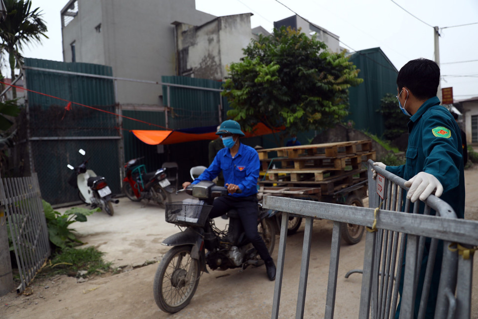 Kiểm soát chặt chẽ người dân trong xã Dũng Tiến đi lại, đồng thời hạn chế không cho người ngoài vào thôn Đông Cứu. (Ảnh: Minh Quyết/ TTXVN)