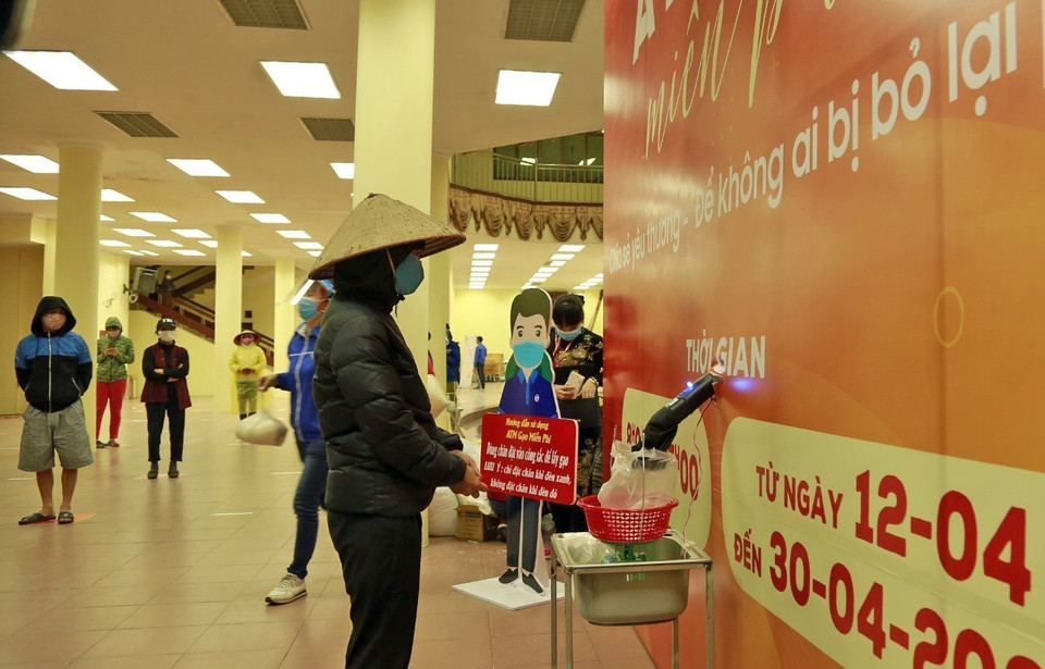 Người nghèo, người có hoàn cảnh khó khăn nhận gạo miễn phí từ cây ATM gạo đặt tại phường Phúc Diễn, quận Bắc Từ Liêm, Hà Nội. (Ảnh: TTXVN)