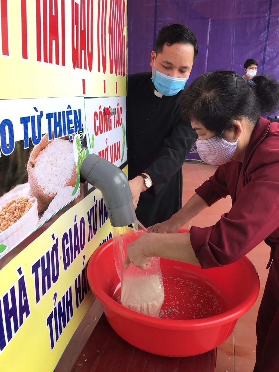 Người có hoàn cảnh khó khăn tại Hải Dương nhận gạo miễn phí từ cây ATM gạo. (Ảnh: TTXVN)