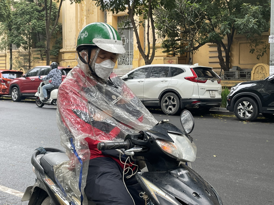 Một tài xế công nghệ đang tranh thủ nghỉ ngơi bên lề phố. (Ảnh: PV/Vietnam+)