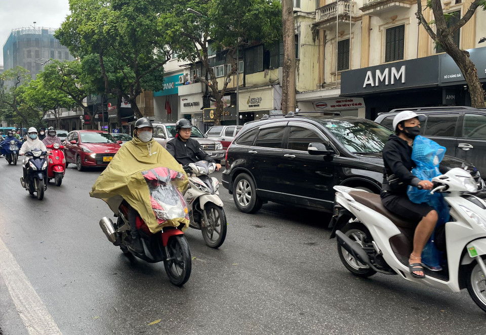 Thời tiết mưa ít nhiều làm ảnh hưởng đến việc di chuyển của người dân Thủ đô. (Ảnh: PV/Vietnam+)
