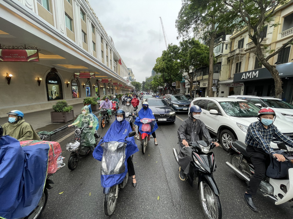 Sáng 25/4, nhiều người dân Thủ đô đã ra đường với trang phục quần áo dài tay trong thời tiết se lạnh. (Ảnh: PV/Vietnam+)