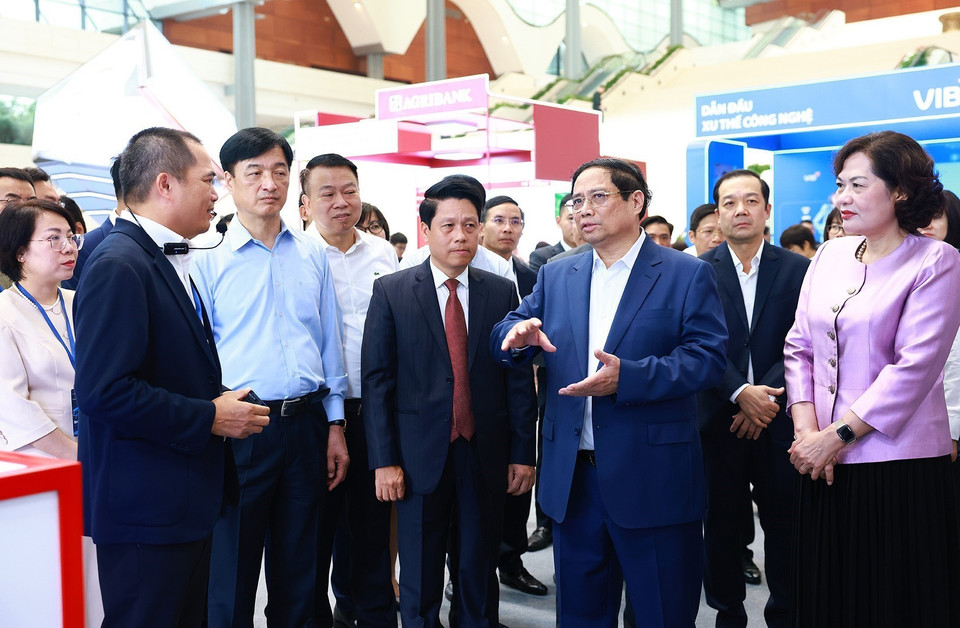 Thủ tướng Phạm Minh Chính tham quan trưng bày về ứng dụng chuyển đổi số trong lĩnh vực ngân hàng. (Ảnh: Dương Giang/TTXVN)