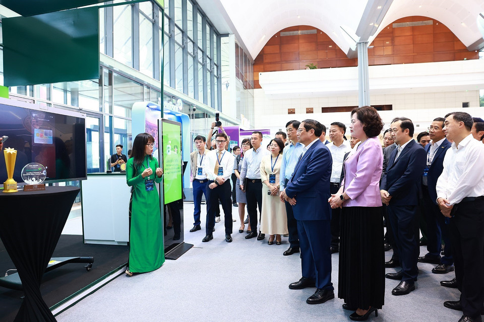 Thủ tướng Phạm Minh Chính tham quan trưng bày về ứng dụng chuyển đổi số trong lĩnh vực ngân hàng. (Ảnh: Dương Giang/TTXVN)