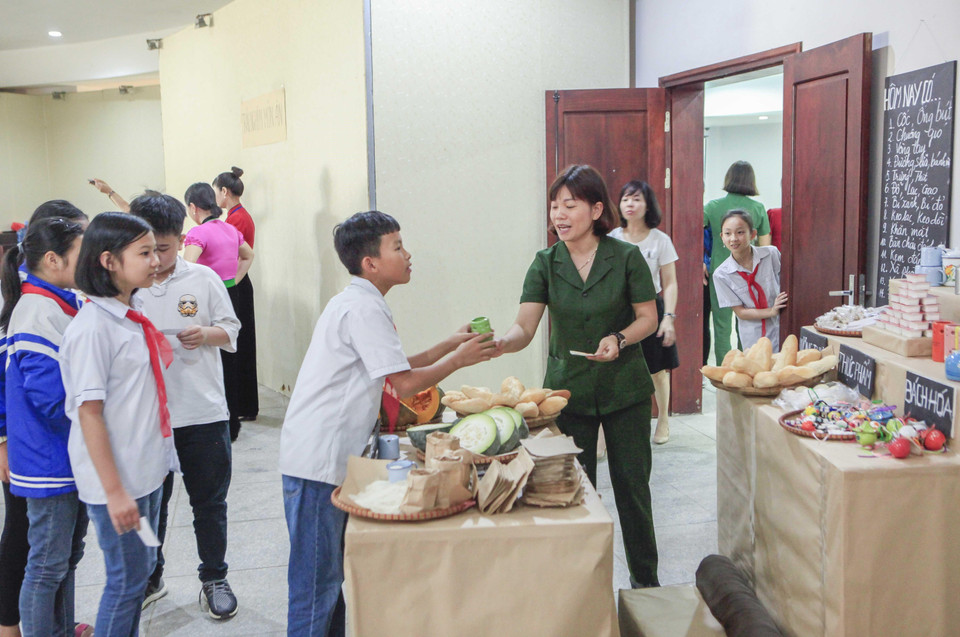 Học sinh xếp hàng đổi tem phiếu lấy vật dụng tại cửa hàng mậu dịch. (Ảnh: Xuân Tư/TTXVN)