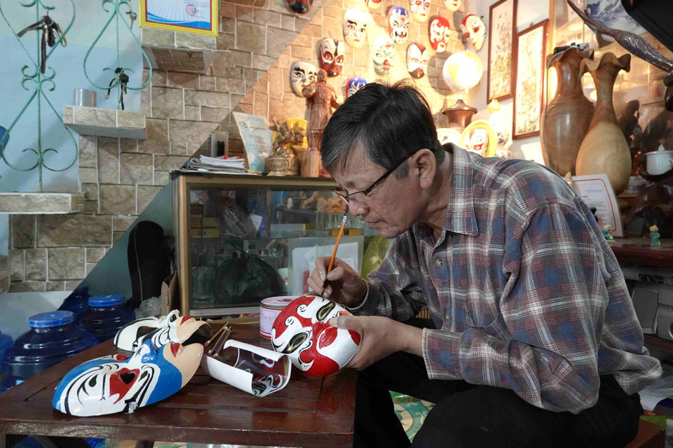 Để hoàn thành một sản phẩm mặt nạ chân dung nghệ thuật hát bội, ông Vân nhập tâm vào nhân vật vẽ trong 2 giờ. (Ảnh: Tường Quân/TTXVN)