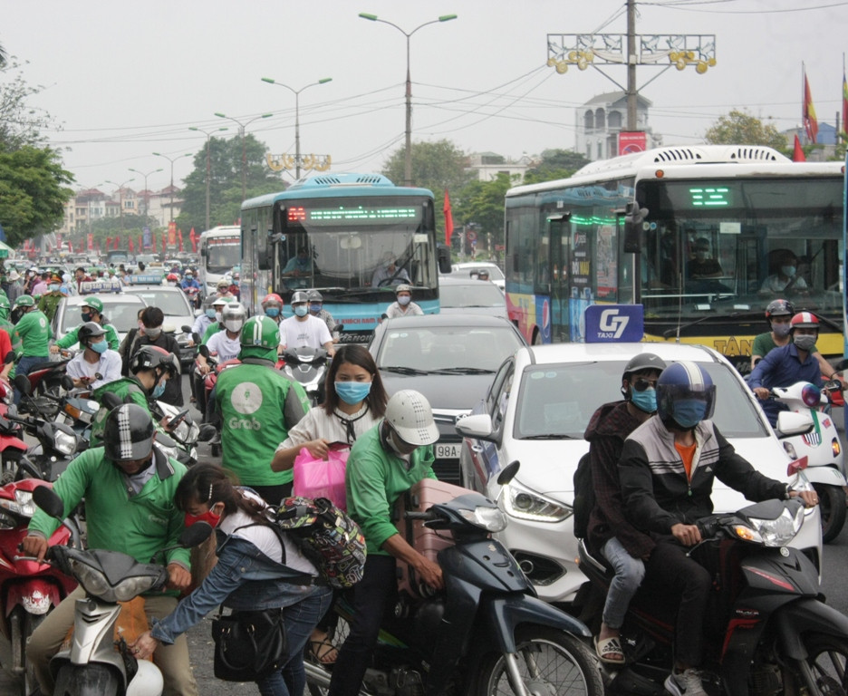Đông đảo tài xế xe công nghệ chèo kéo khách khiến đoạn cổng vào bến xe Giáp Bát bị ùn tắc. (Ảnh: Việt Hùng/Vietnam+)