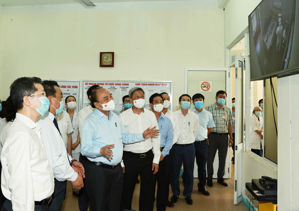 Chủ tịch nước Nguyễn Xuân Phúc quan sát các bác sỹ đang điều trị cho các bệnh nhân mắc COVID-19 trong Khu cách ly tại Bệnh viện phổi Đà Nẵng. (Ảnh: Thống Nhất/TTXVN)