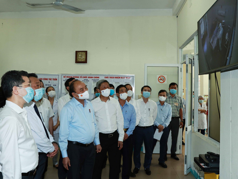 Chủ tịch nước Nguyễn Xuân Phúc quan sát các bác sỹ đang điều trị cho các bệnh nhân mắc COVID-19 trong Khu cách ly tại Bệnh viện phổi Đà Nẵng. (Ảnh: Thống Nhất/TTXVN)