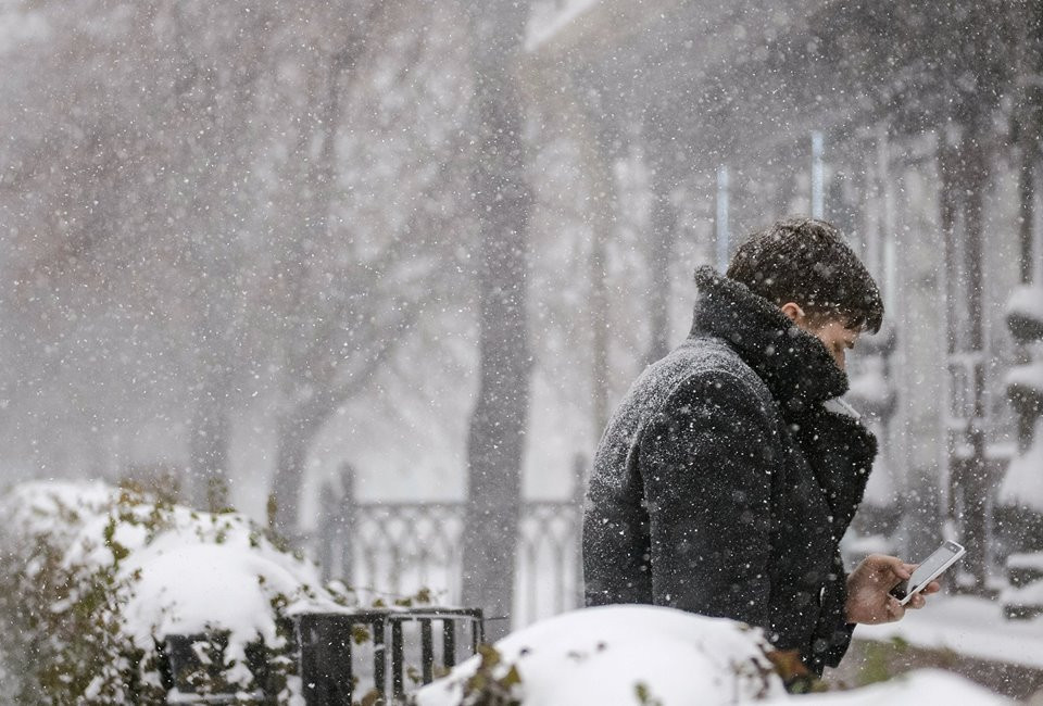 Một người đàn ông cố sử dụng điện thoại ngoài trời. (Nguồn: Sputnik)