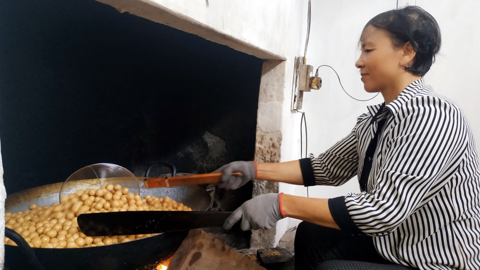 Công đoạn rán bánh nhãn. (Ảnh: Nguyễn Lành/TTXVN)