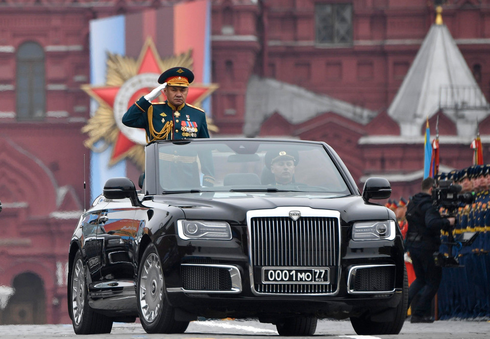 Bộ trưởng Quốc phòng Sergey Shoigu đứng trên chiếc xe siêu sang Cabriolet Aurus do Nga sản xuất thay cho xe ZIL như mọi năm. (Ảnh: AFP/TTXVN)
