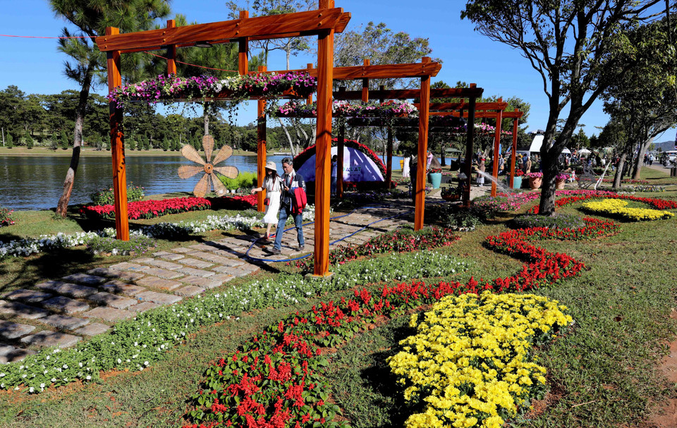 Người dân Đà Lạt thưởng thức không gian hoa xung quanh hồ Xuân Hương. (Ảnh: Nhật Anh/TTXVN)