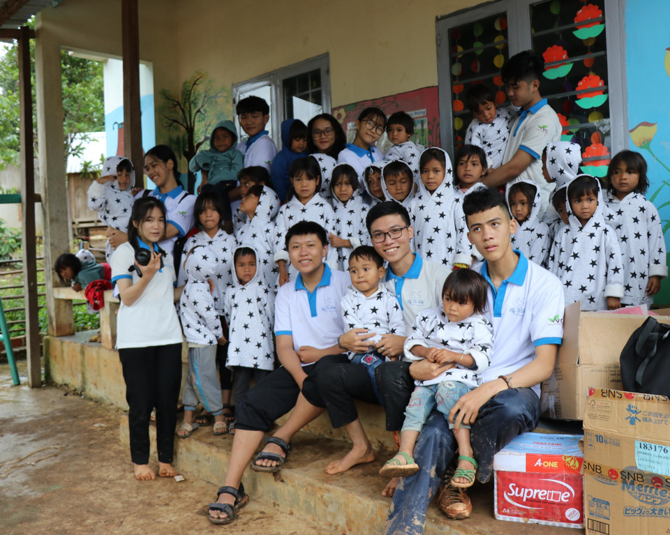 Các em học sinh nhóm thiện nguyện Fly to Sky mang áo ấm đến cho trẻ em làng Đê Kôn. (Ảnh: Hồng Điệp/TTXVN)