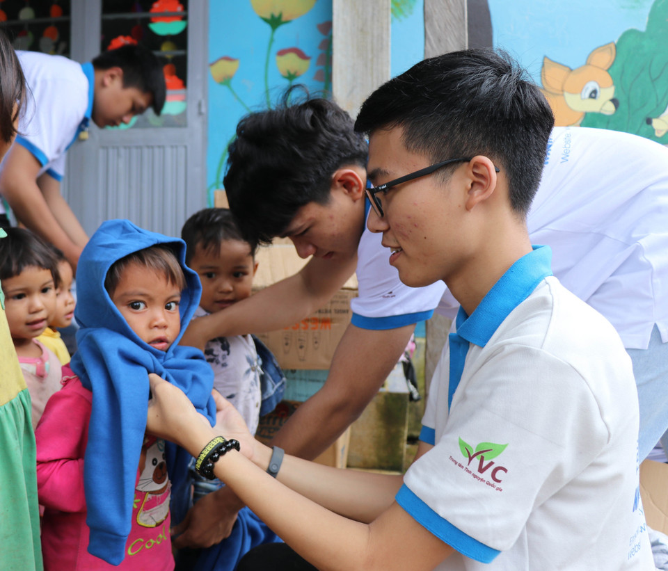  Các em học sinh nhóm thiện nguyện Fly to Sky mang áo ấm đến cho trẻ em làng Đê Kôn. (Ảnh: Hồng Điệp/TTXVN)