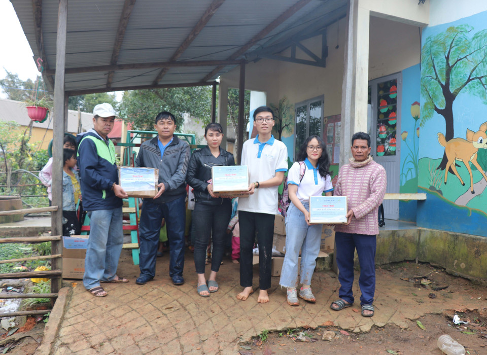 Các em học sinh nhóm thiện nguyện Fly to Sky mang áo ấm, sách truyện và bình lọc nước đến cho trẻ em làng Đê Kôn. (Ảnh: Hồng Điệp/TTXVN)