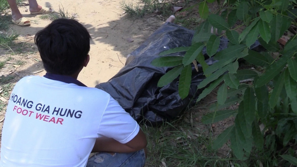 Thi thể của nạn nhân mất tích được đưa từ dưới sông lên bờ chờ nhận dạng. (Ảnh: Nguyễn Văn Việt/TTXVN)