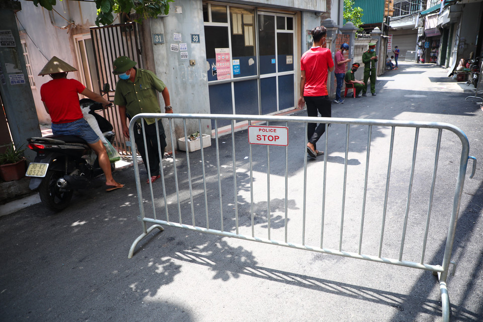 Lực lượng chức năng phong tỏa khu vực ngõ 230/26 Mễ Trì Thượng, nơi có trường hợp nghi nhiễm COVID-19 đang sinh sống để phun thuốc khử khuẩn. (Ảnh: Lê Phú/TTXVN)