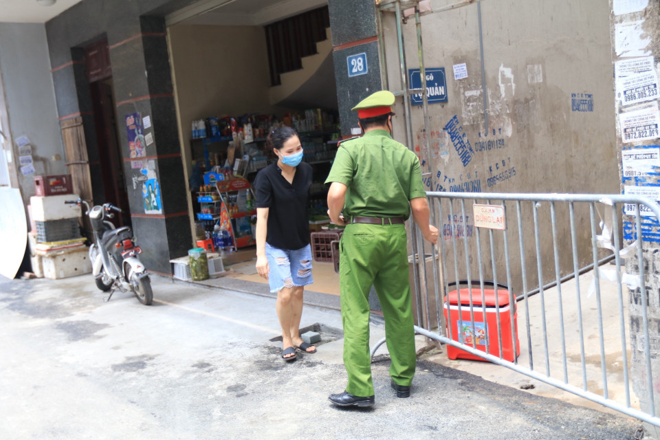 Lực lượng chức năng phong tỏa khu vực ngõ 230/26 Mễ Trì Thượng, nơi có trường hợp nghi nhiễm COVID-19 đang sinh sống để phun thuốc khử khuẩn. (Ảnh: Lê Phú/TTXVN)