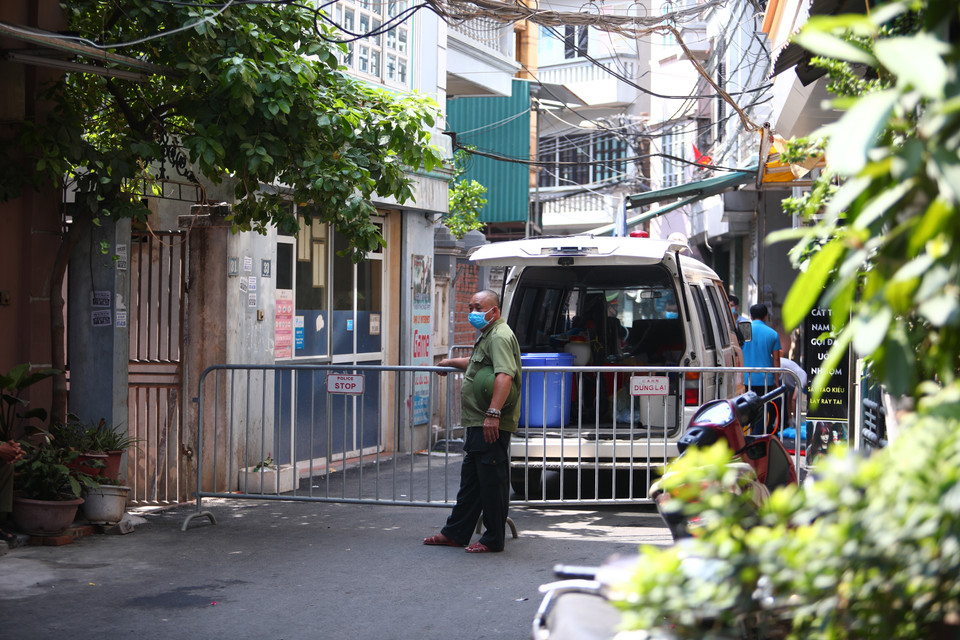 Lực lượng chức năng phong tỏa khu vực ngõ 230/26 Mễ Trì Thượng, nơi có trường hợp nghi nhiễm COVID-19 đang sinh sống để phun thuốc khử khuẩn. (Ảnh: Lê Phú/TTXVN)