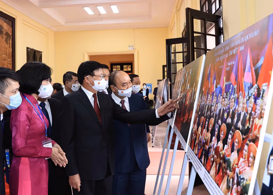 Phó Tổng Giám đốc Vũ Việt Trang giới thiệu trưng bày ảnh Quan hệ hữu nghị vĩ đại, đoàn kết đặc biệt và hợp tác toàn diện Việt Nam-Lào của TTXVN với Tổng Bí thư, Chủ tịch nước Lào Thongloun Sisoulith và Chủ tịch nước Nguyễn Xuân Phúc. (Ảnh: Thống Nhất/TTXVN)