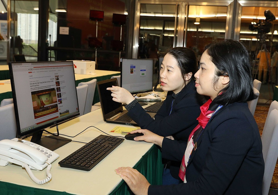 Các biên tập viên Ban biên tập tin Đối ngoại TTXVN làm việc tại Trung tâm báo chí Đại hội XIII của Đảng. (Ảnh: TTXVN)