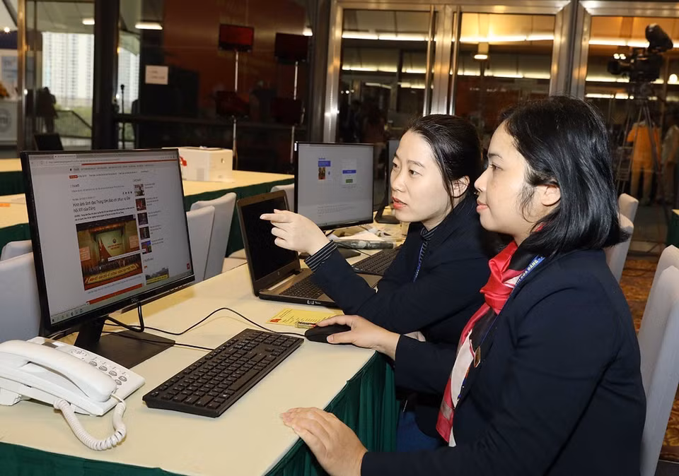 Các biên tập viên Ban biên tập tin Đối ngoại TTXVN làm việc tại Trung tâm báo chí Đại hội XIII của Đảng. (Ảnh: TTXVN)