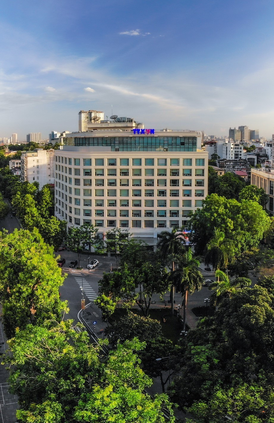 Tòa nhà Thông tấn - ngôi nhà chung của các thế hệ phóng viên, biên tập viên Thông tấn xã Việt Nam nổi bật giữa màu xanh của cây lá. (Ảnh: Phạm Tuấn Anh/TTXVN)