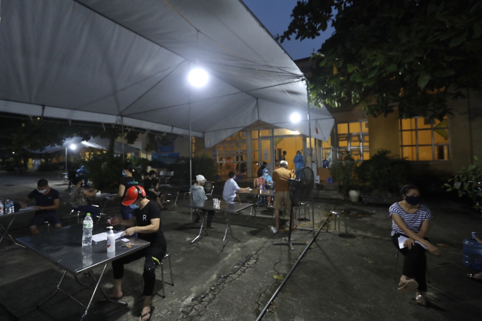 Nhằm tăng cường tốc độ tiêm chủng vaccine phòng COVID-19 cho người dân, sự hỗ trợ về nhân lực của tỉnh Phú Thọ, xã Tam Hiệp (huyện Thanh Trì) thực hiện tiêm đến tối muộn cho người dân. (Ảnh: Minh Quyết/TTXVN)