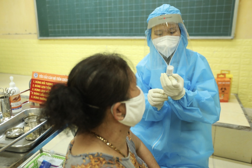 Nhằm tăng cường tốc độ tiêm chủng vaccine phòng COVID-19 cho người dân, sự hỗ trợ về nhân lực của tỉnh Phú Thọ, xã Tam Hiệp (huyện Thanh Trì) thực hiện tiêm đến tối muộn cho người dân. (Ảnh: Minh Quyết/TTXVN)