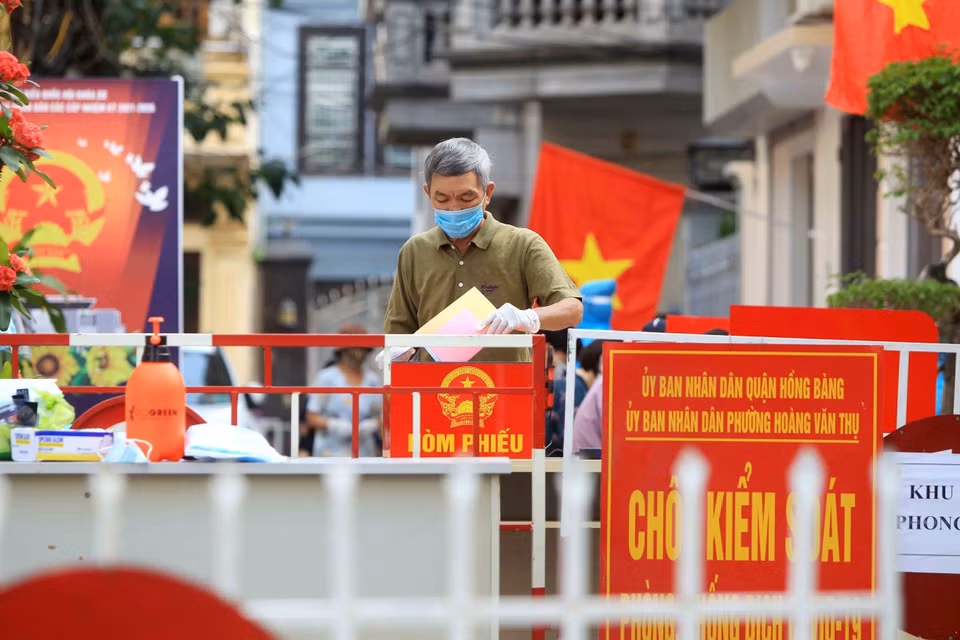 Phóng viên TTXVN ghi lại hình ảnh cử tri tại ngõ 10 Phan Chu Trinh, phường Hoàng Văn Thụ, thành phố Hải Phòng, nơi thường trú của bệnh nhân mắc COVID-19 số 3480 thuộc Tổ bầu cử số 2 đang bỏ phiếu bầu tại Tổ bầu cử số 2 (23/5/2021). (Ảnh: An Đăng/TTXVN)