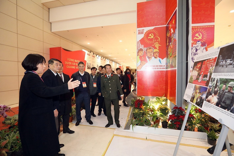 Phó Tổng Giám đốc TTXVN Vũ Việt Trang giới thiệu với đoàn công tác do ông Lê Minh Hưng, Ủy viên Trung ương Đảng, Chánh Văn phòng Trung ương Đảng làm trưởng đoàn về khu trưng bày ảnh của Thông tấn xã Việt Nam tại Đại hội XIII của Đảng (Trung tâm Hội nghị quốc gia, Hà Nội). (Ảnh: Phan Tuấn Anh/TTXVN)